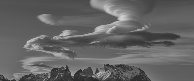 ufo-shaped clouds above mountains, black and white photo