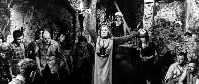 woman dressed as a witch performing a ritual, black and white image.