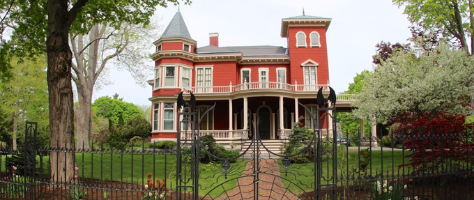 Stephen King's red and white victorian with spiderweb wrought iron gate