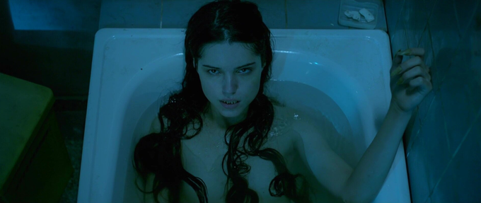 a mermaid with razor teeth and long wet hair in a bathtub