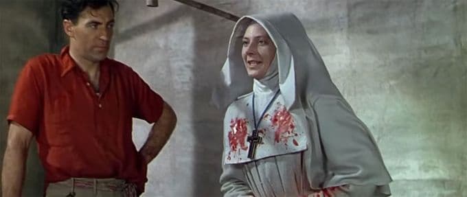 Film still from "Black Narcissus" of featured villain Sister Ruth with crazed look and bloody habit.