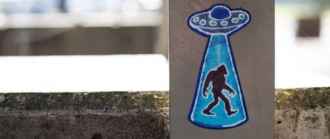 A graffiti drawing of Bigfoot being abducted by a UFO.